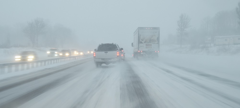 Cars and trucks driving on a snowy highway