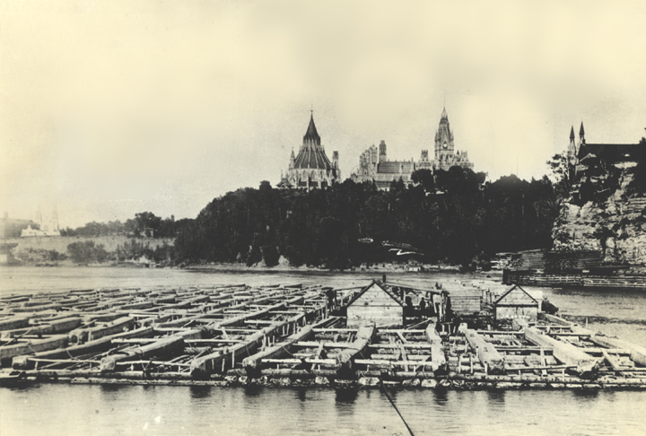 1909 archival photo of log drive on Ottawa River with Parliament buildings in background