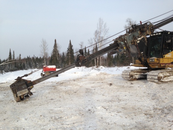 Mobile head of mechanical harvesting equipment on a winter's day in northern Ontario bush.