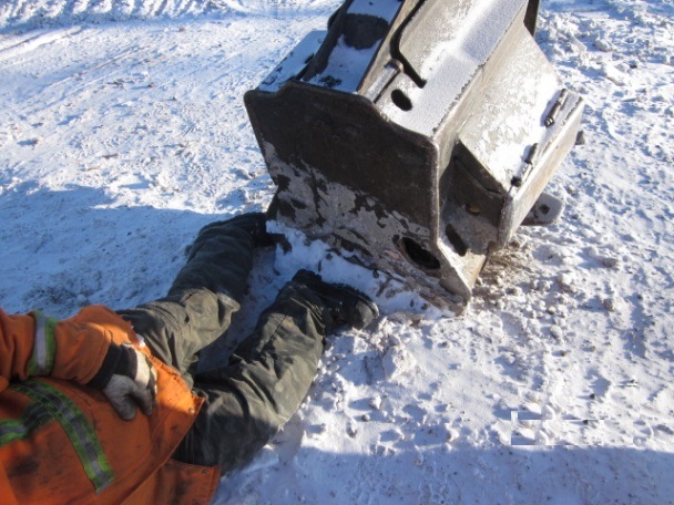 Worker legs pinned in snow under mobile head of equipment