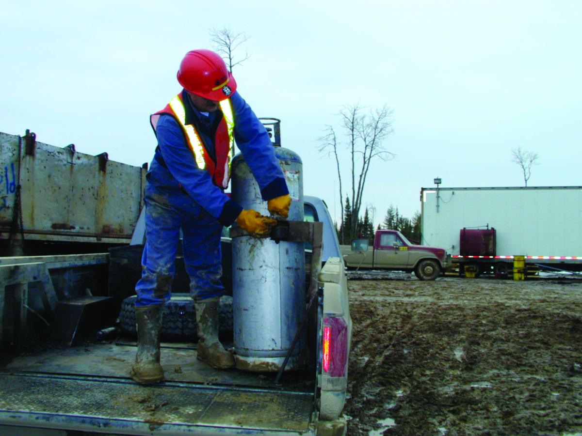 Outdoor worker handling propane tank