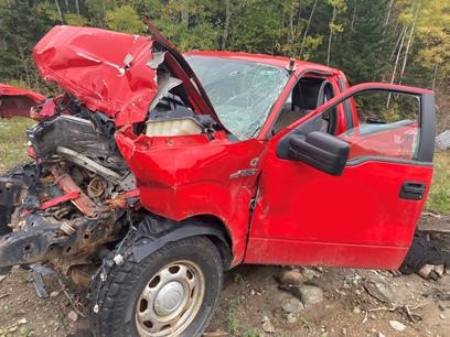 Front end of pickup truck crumpled and smashed from motor vehicle collision.