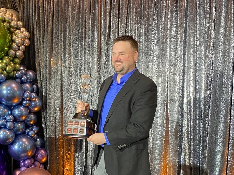 Man holding trophy standing on stage