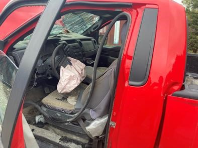 Driver's seat with deployed airbag on damaged pickup truck