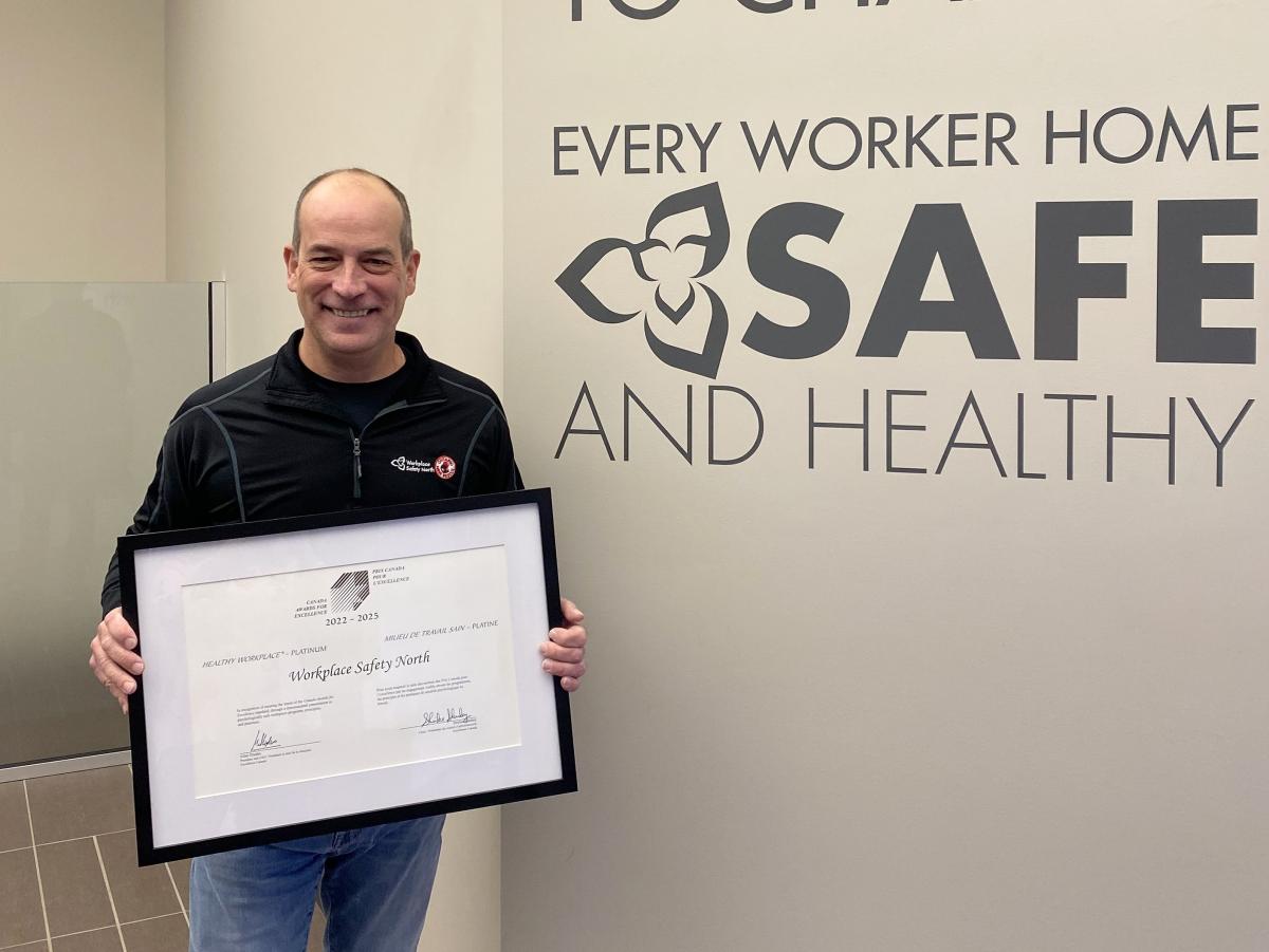 Man holding framed certificate